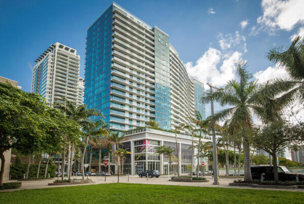 A large building with palm trees in front of it.