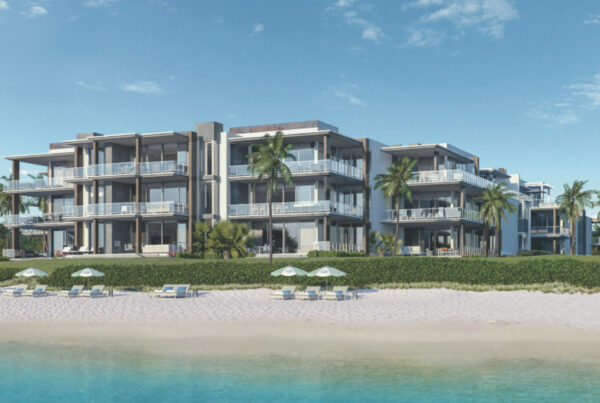 A beach front building with palm trees and the ocean.