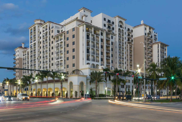 A large hotel with palm trees and lights in the background.